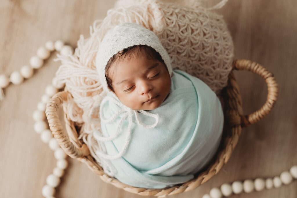 Best Newborn Photography on the Gold Coast QLD Newborn baby in basket with blue wrap and bonnet 